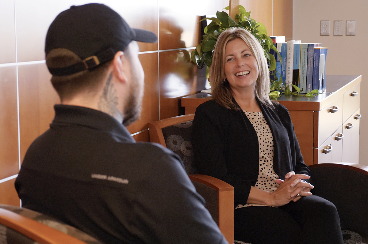 woman facing camera talking to man with back to camera